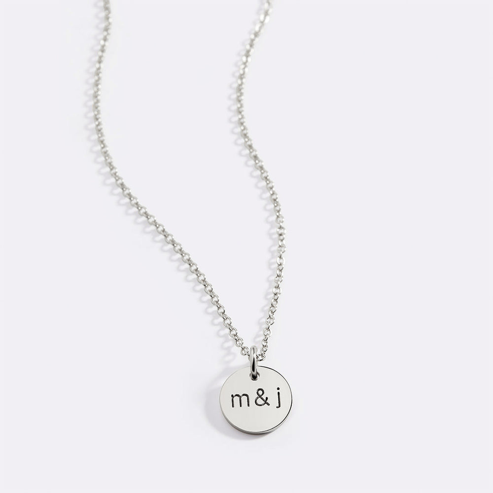 A gold-plated necklace with a circular pendant featuring the initial 'K'.