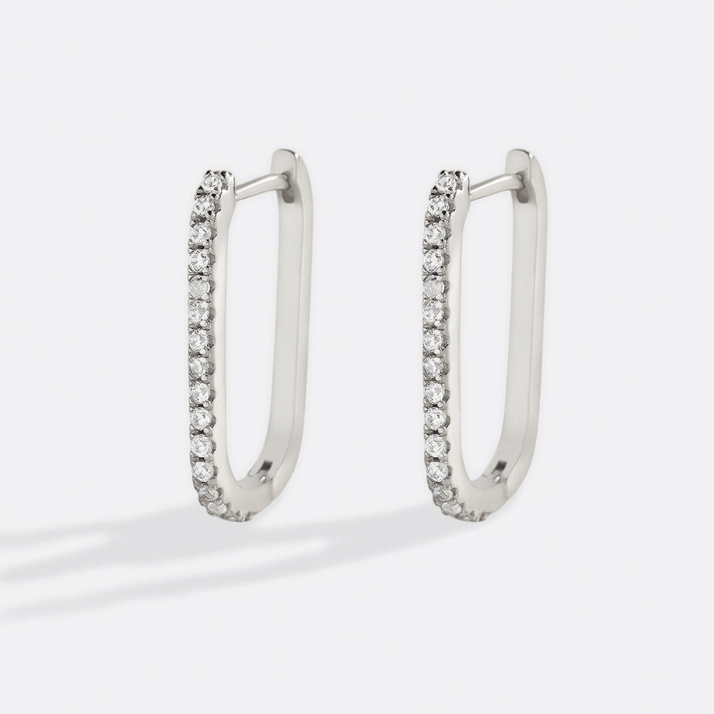A pair of gold vermeil hoop earrings with pave cubic zirconia stones, displayed against a black background.