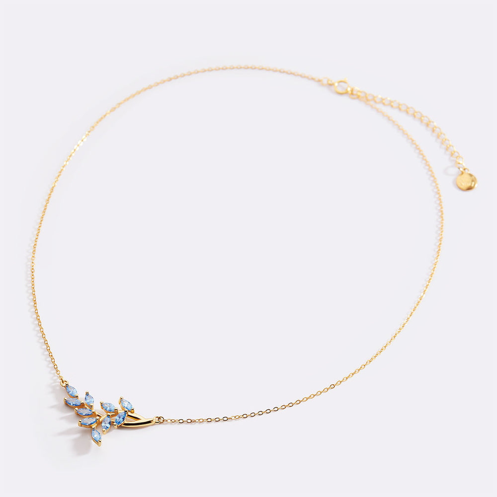 Gold necklace with a decorative clasp on a light gray background