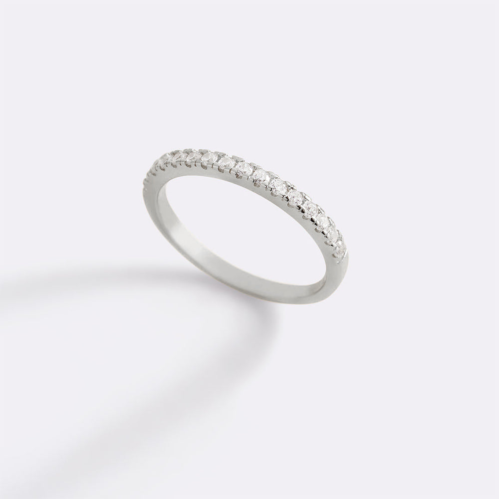 Silver ring with small diamonds on a light gray background