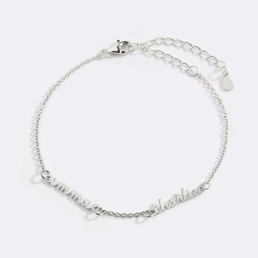 A gold-colored dainty cable chain bracelet with a lobster clasp, featuring multiple nameplates.