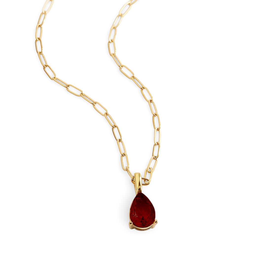 Gold necklace with a red teardrop pendant on a white background