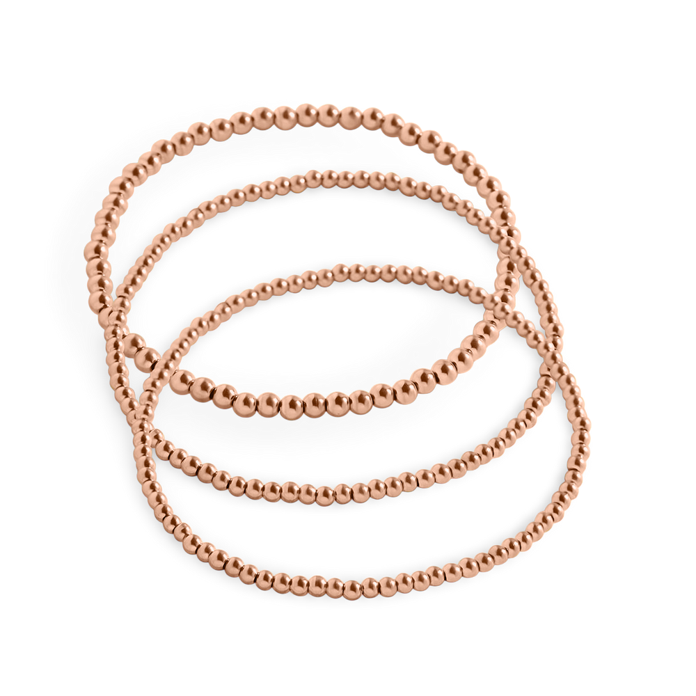 A set of gold-colored beaded bracelets stacked together.