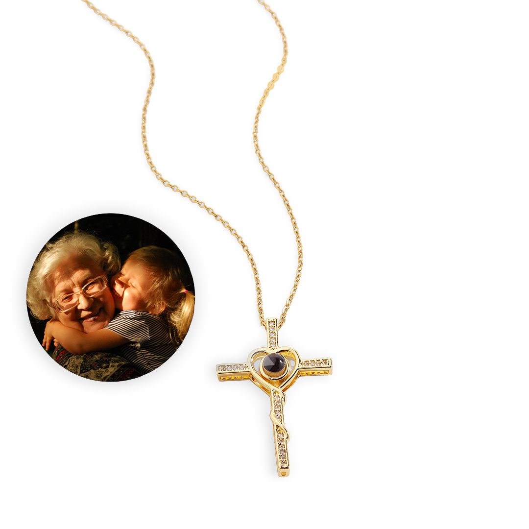 An 18k gold photo necklace with a heart and cross pendant, displayed alongside an inset image of an older couple smiling.