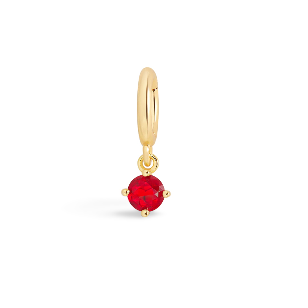 Gold earring with a red gemstone on a light gray background