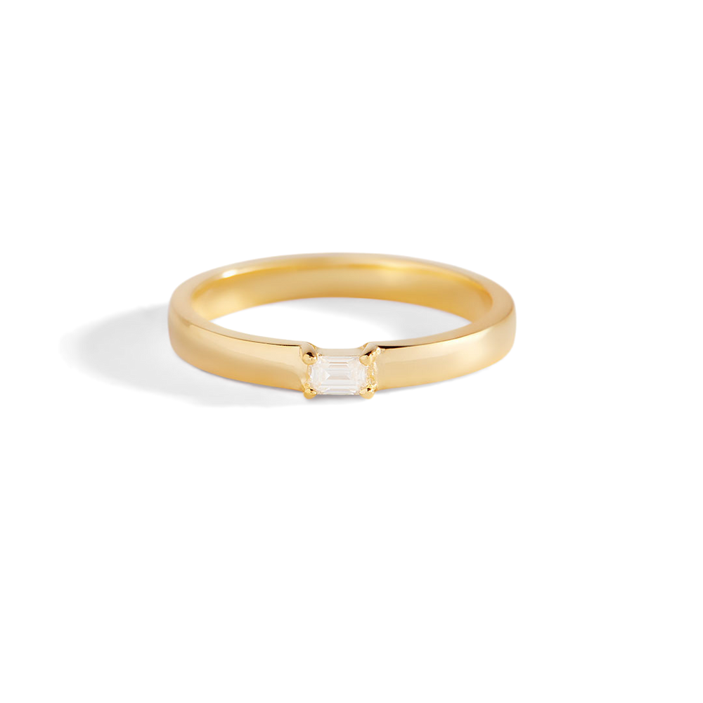 Gold ring with a diamond on a light gray background