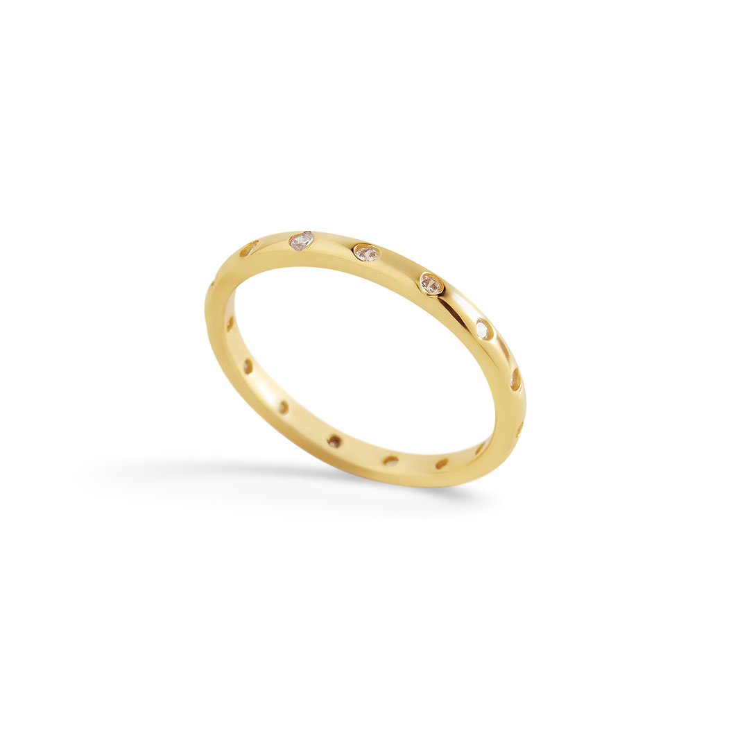 Gold ring with embedded diamonds on a light gray background