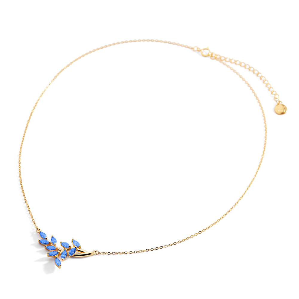 Gold necklace with blue stones on a light gray background