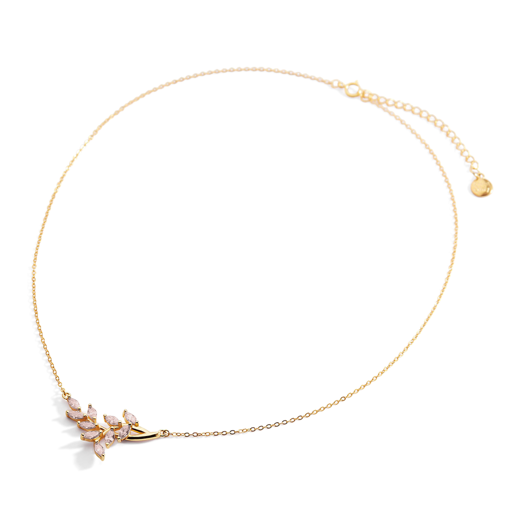 Gold necklace with a delicate pendant on a light gray background