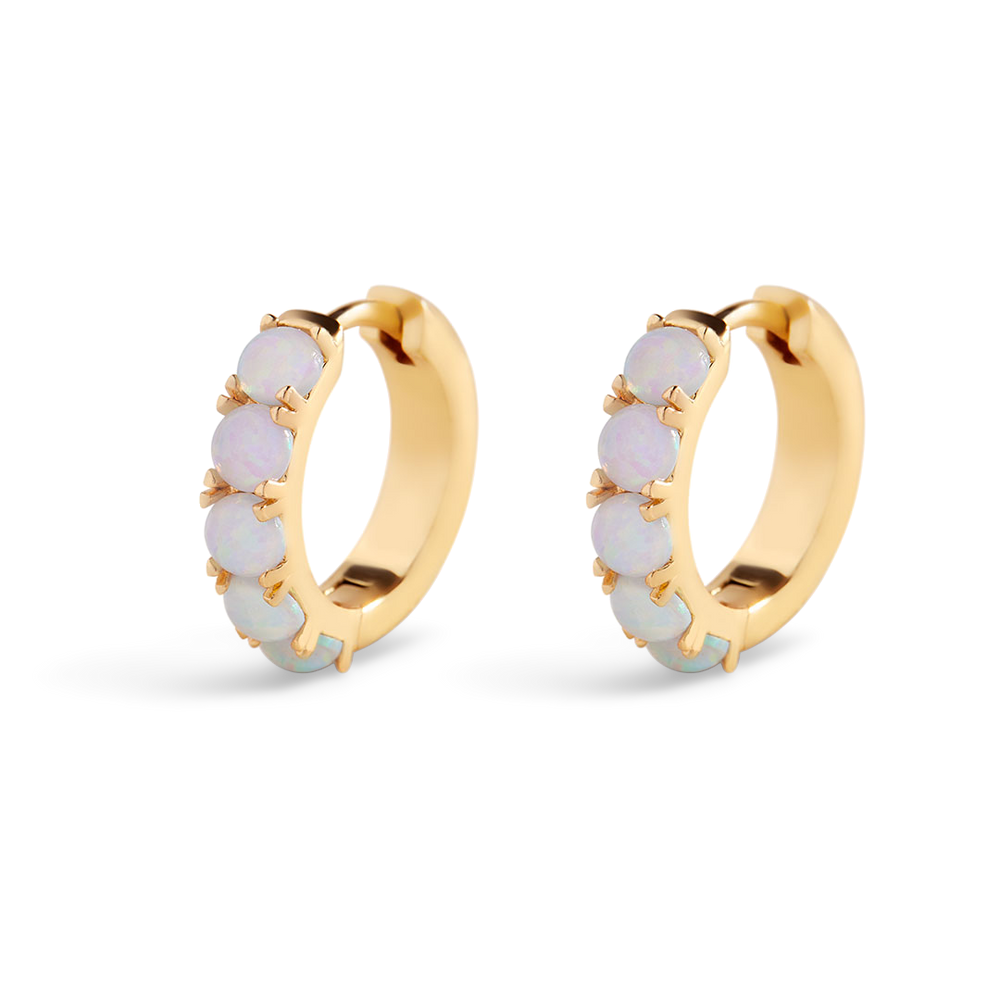 Gold hoop earrings with purple gemstones on a white background