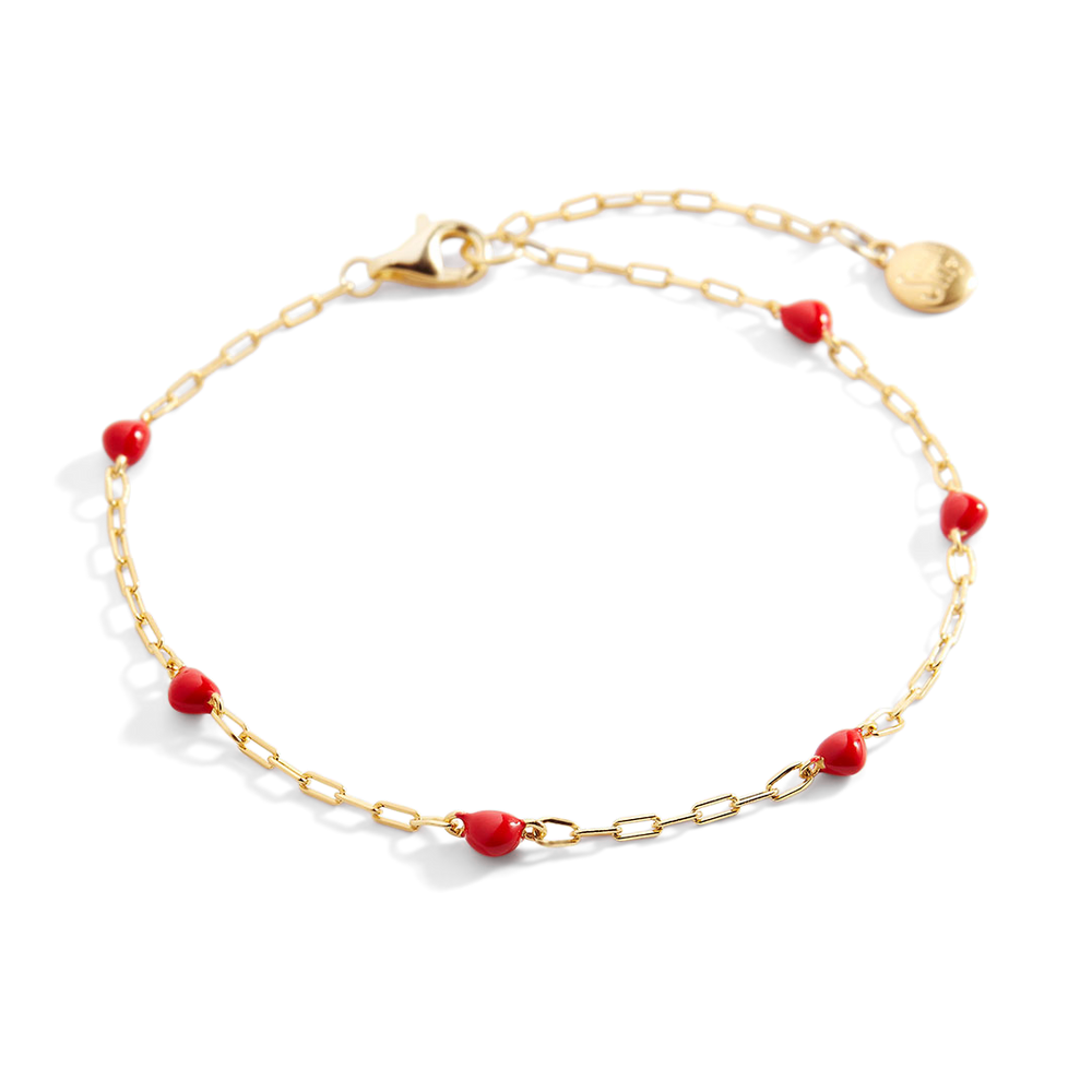 Gold bracelet with red beads on a white background