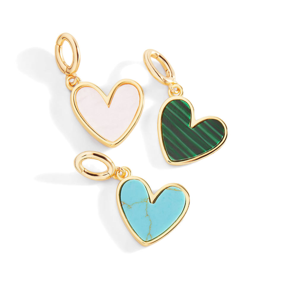 Three heart-shaped pendants with gold frames on a white background