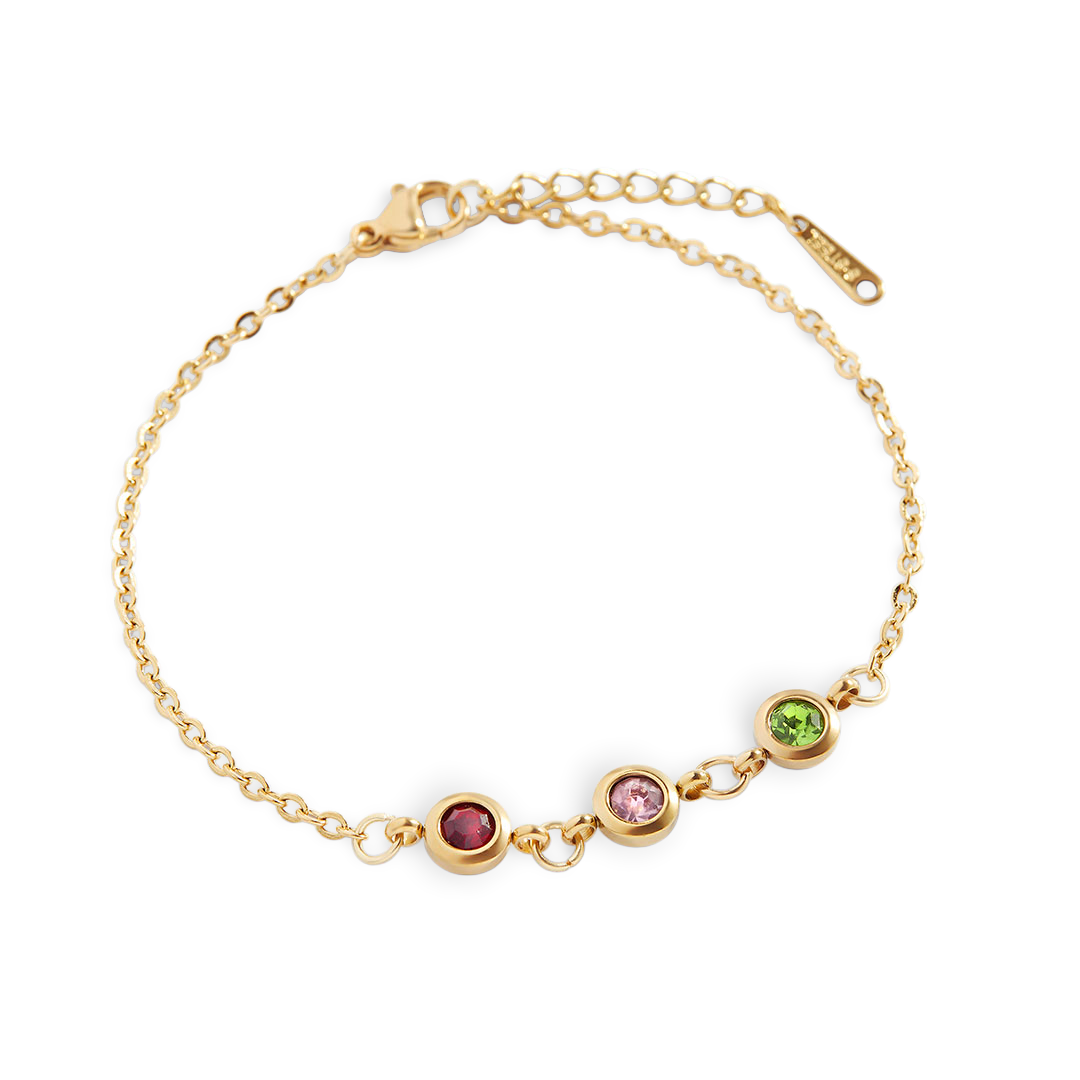A gold-colored bracelet featuring a series of round charms with different colored gemstones in the center, connected by a dainty cable chain.