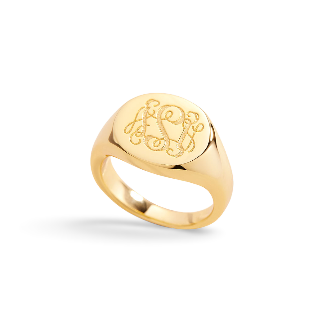 Gold ring with engraved design on a light gray background