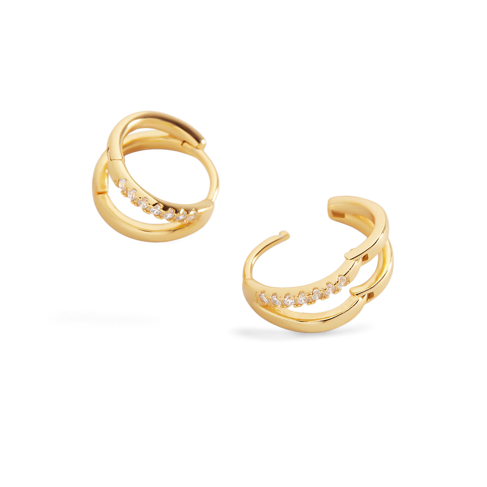 Gold hoop earrings with small diamonds on a light gray background