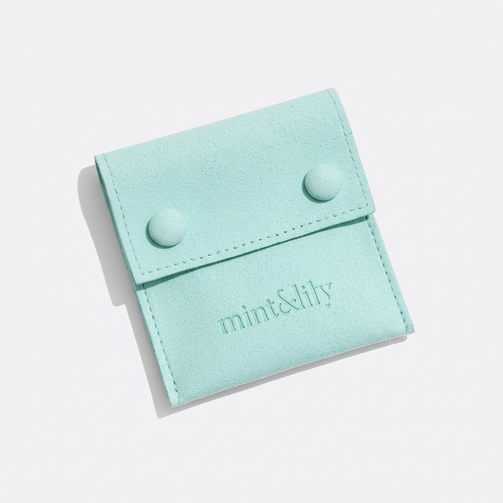 Mint green suede-style Mint & Lily jewelry pouch with two snap closures and embossed logo on a light background.