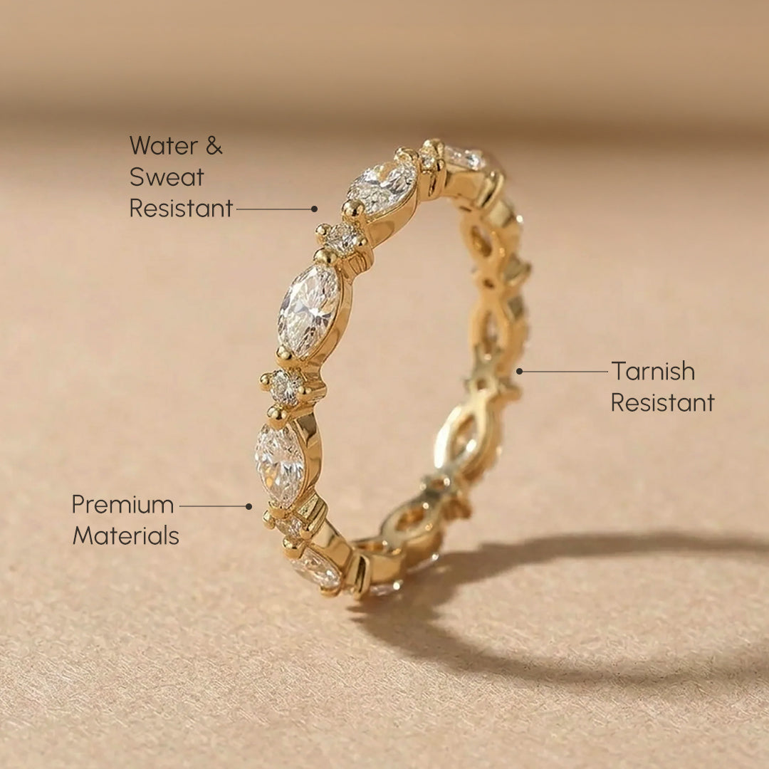 Gold ring with diamond accents on a beige background, labeled for water & sweat resistance, tarnish resistance, and premium materials.