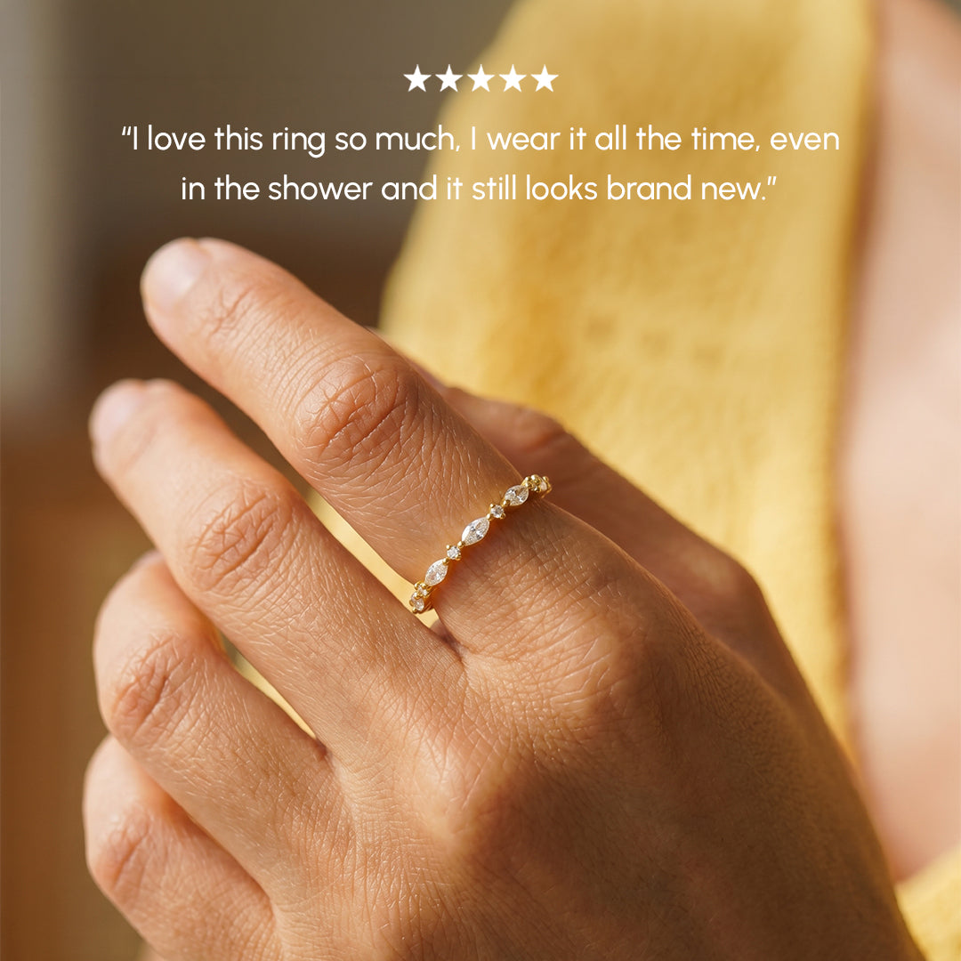 Hand wearing a gold ring with a blurred background
