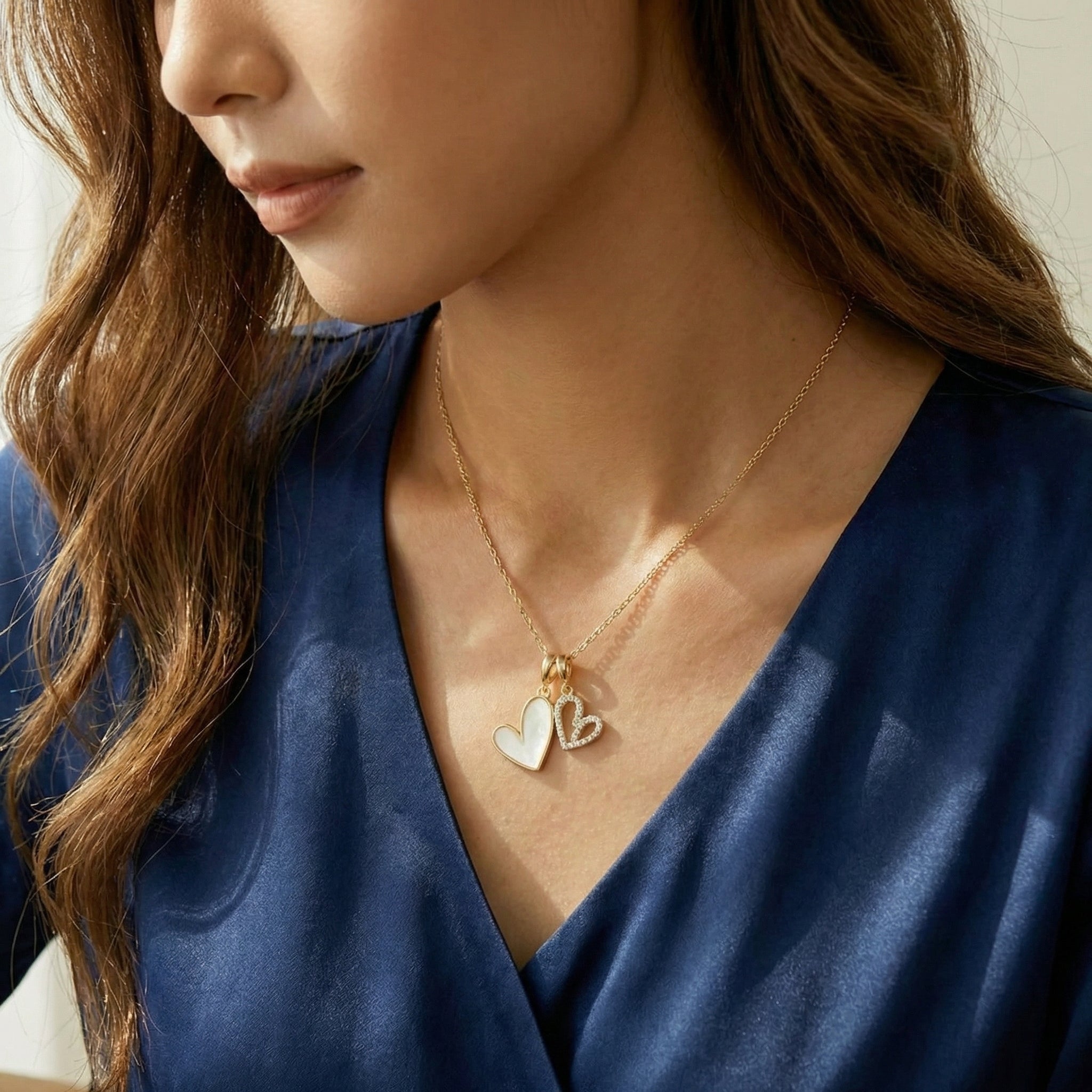 Gold necklace with heart pendants worn by a person