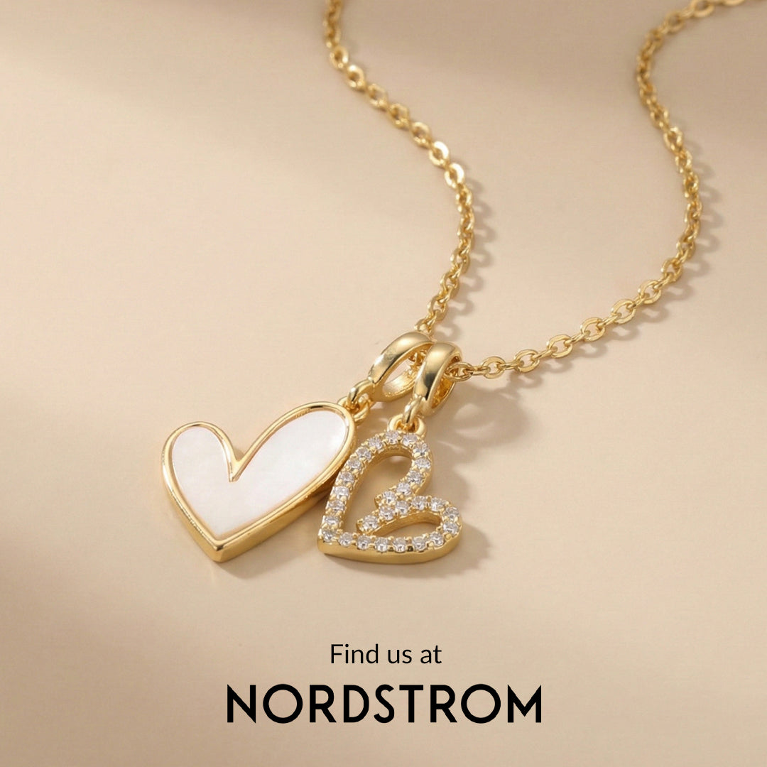 Gold necklace with heart pendants on a beige background, Nordstrom branding visible.