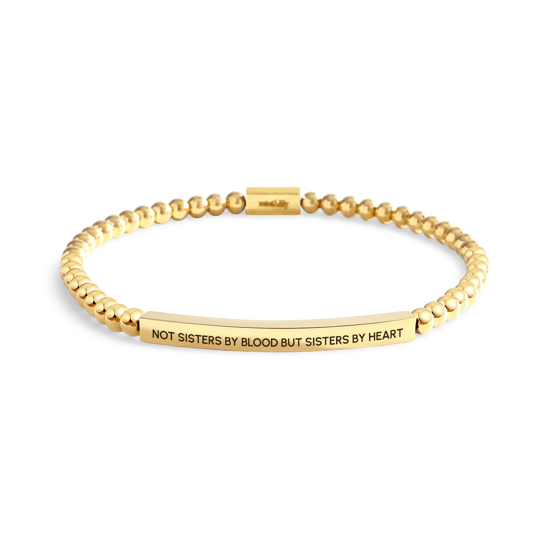 Gold bracelet with engraved message on a white background