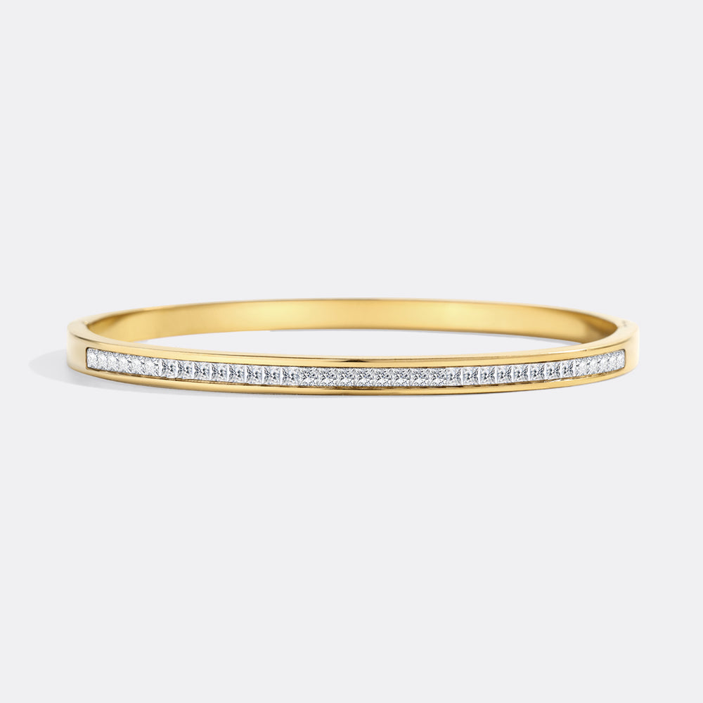 Gold bracelet with small diamonds on a light gray background