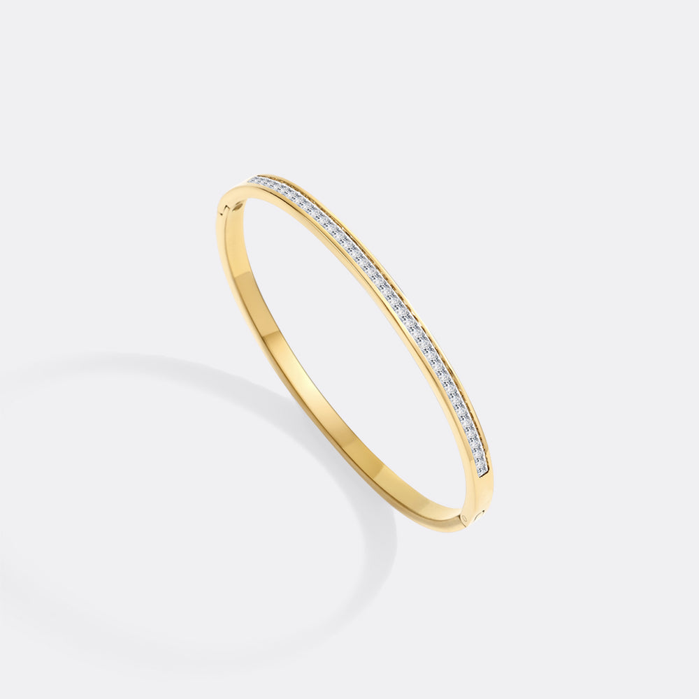 Gold bracelet with embedded diamonds on a light gray background