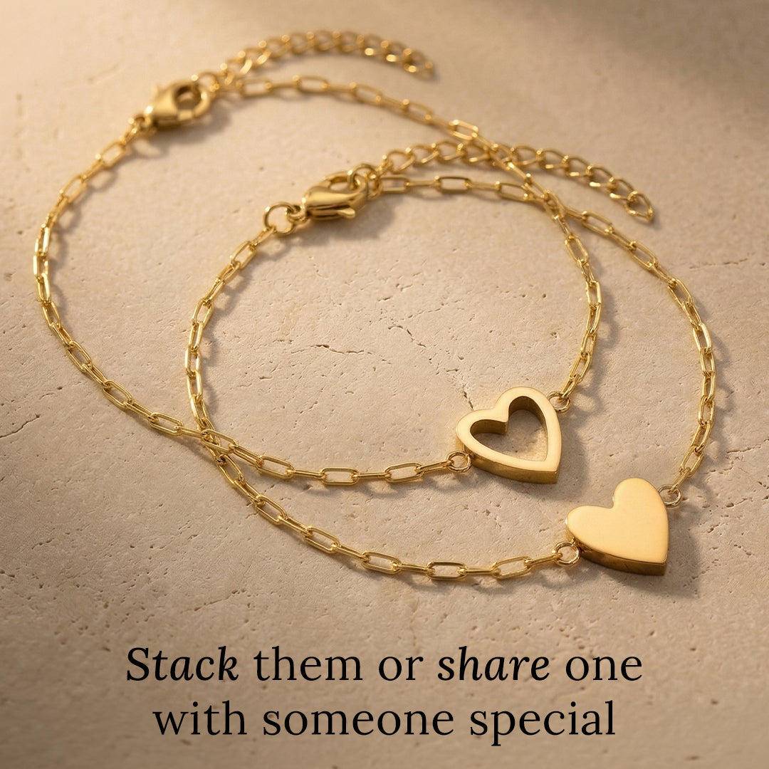Gold heart-shaped bracelet on a textured beige surface with text 'Stack them or share one with someone special'.