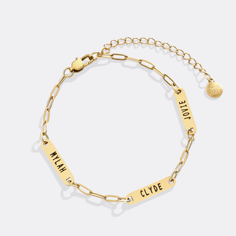 Gold chain bracelet with engraved names on a white background