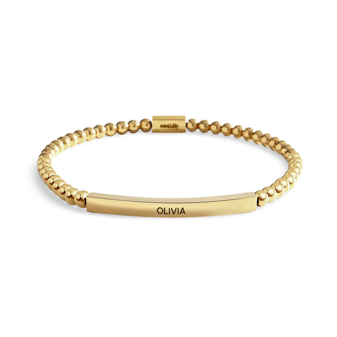 Gold bracelet with 'OLIVIA' engraving on a white background