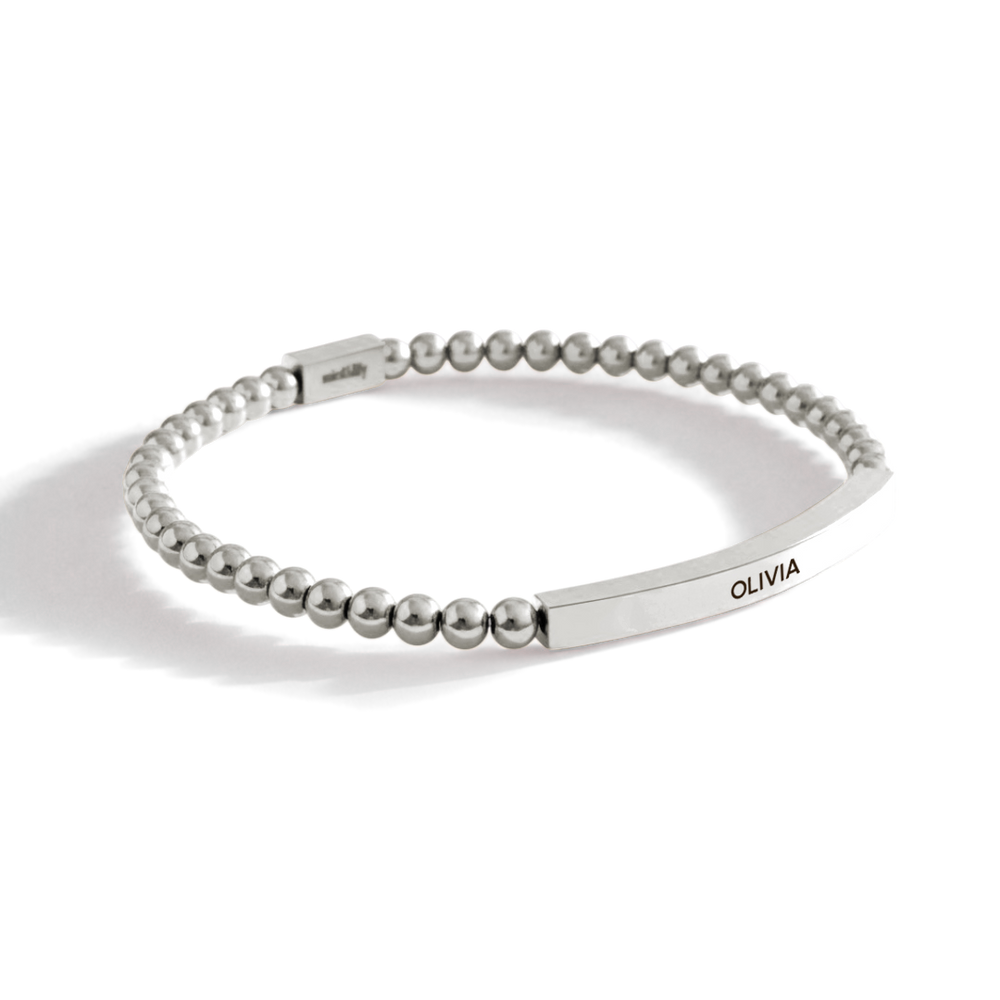 Silver beaded bracelet with engraved name on a white background