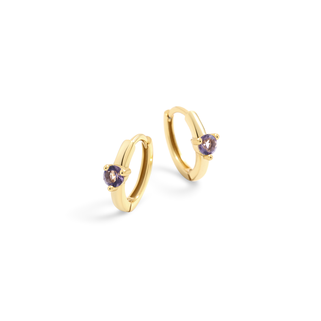 Gold hoop earrings with purple gemstones on a light gray background