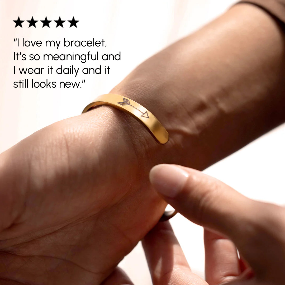 Gold bracelet on a wrist with a five-star rating and customer review text.