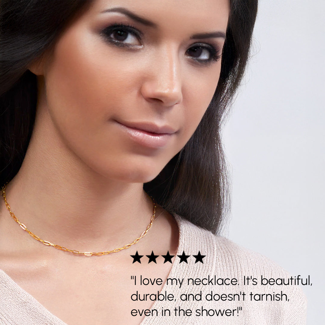 Woman wearing a gold necklace with a neutral background