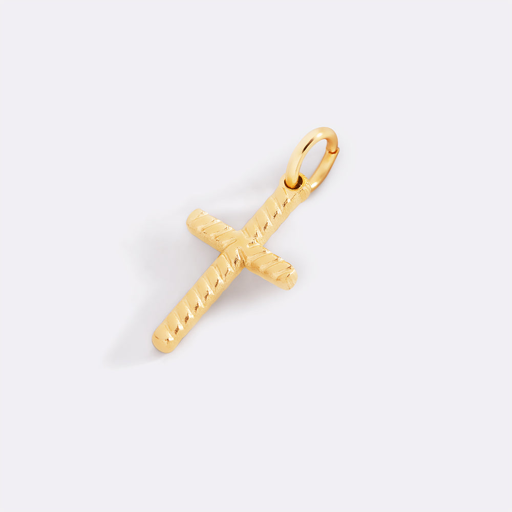 Gold cross pendant on a light gray background