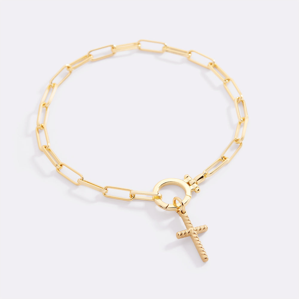 Gold bracelet with a unique charm on a light gray background