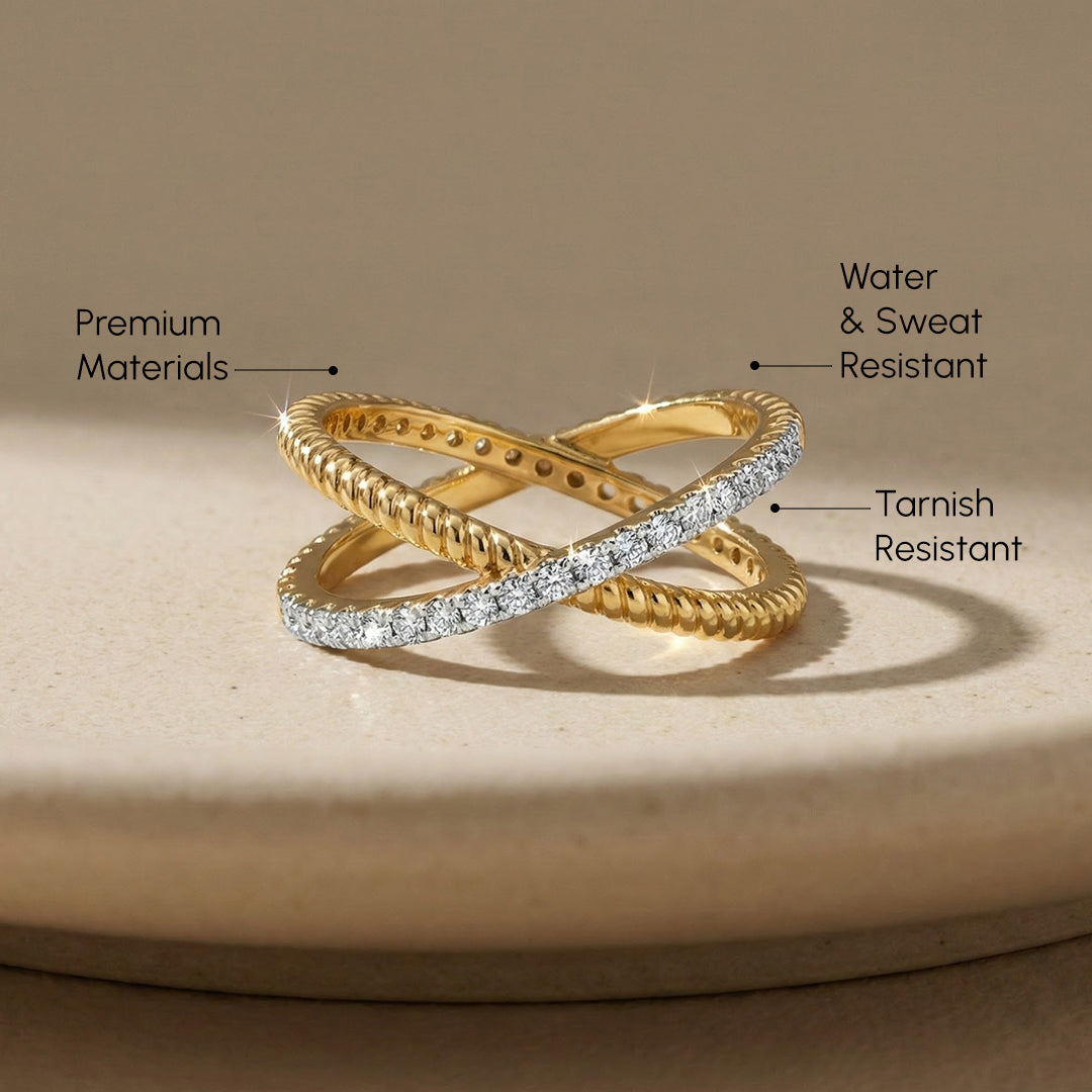 Gold ring with diamond accents on a beige surface, labeled for material, water/sweat resistance, and tarnish resistance.