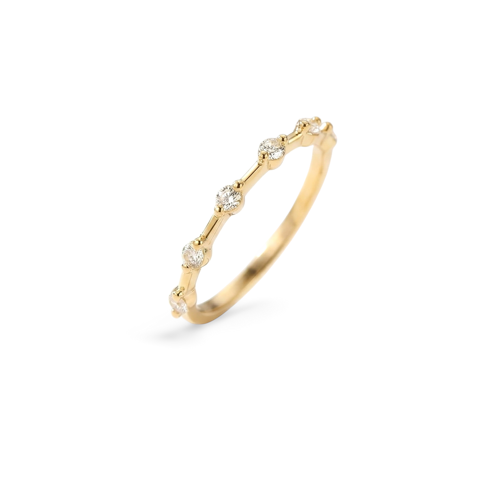 Gold ring with small diamonds on a light gray background