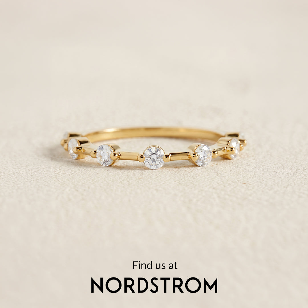 Gold ring with diamonds on a beige background, Nordstrom branding visible