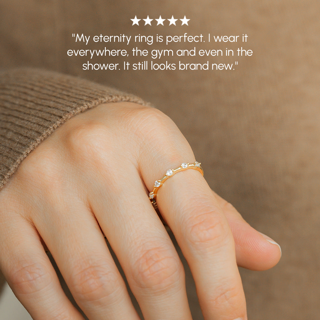 Hand wearing a gold ring with a blurred background