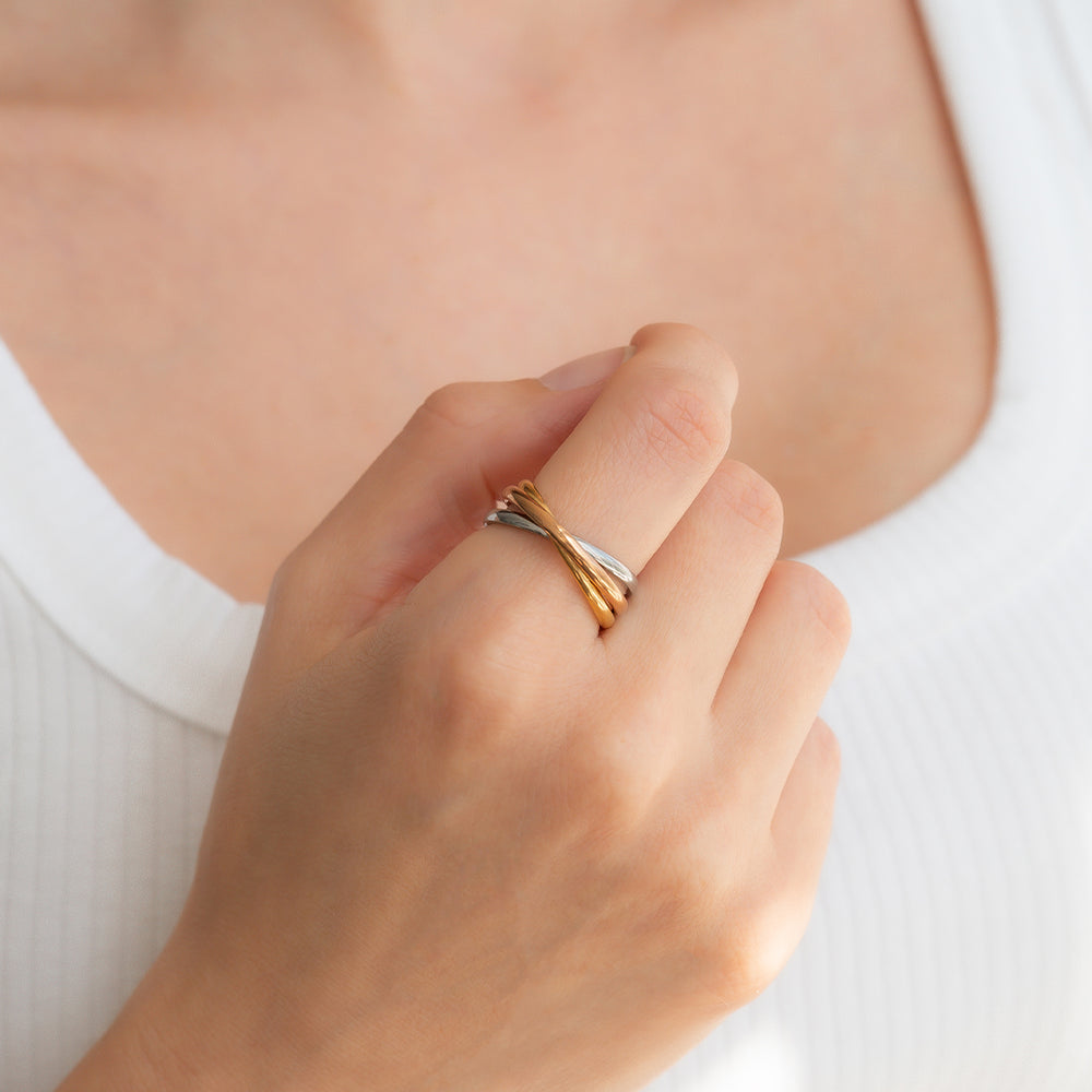 Close-up of a hand wearing a gold ring on a plain background