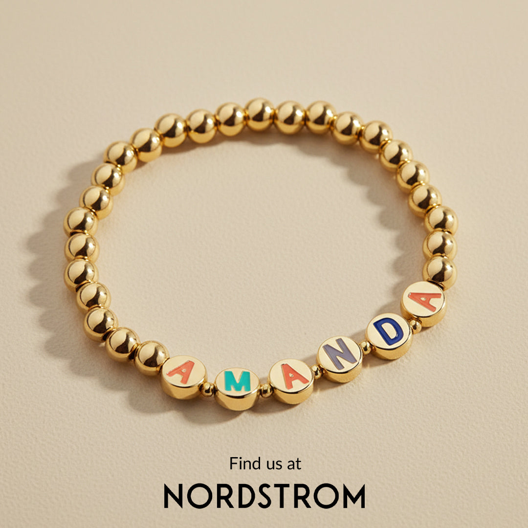Gold bracelet with letter beads spelling 'HAPPY' on a light background, featuring 'WHO WHAT WEAR'.