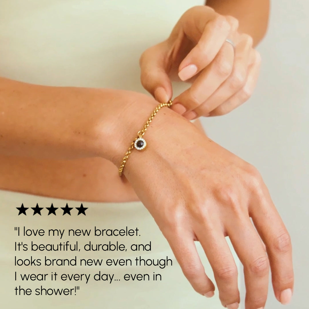 Person wearing a gold bracelet on a plain background with a five-star rating and review text.