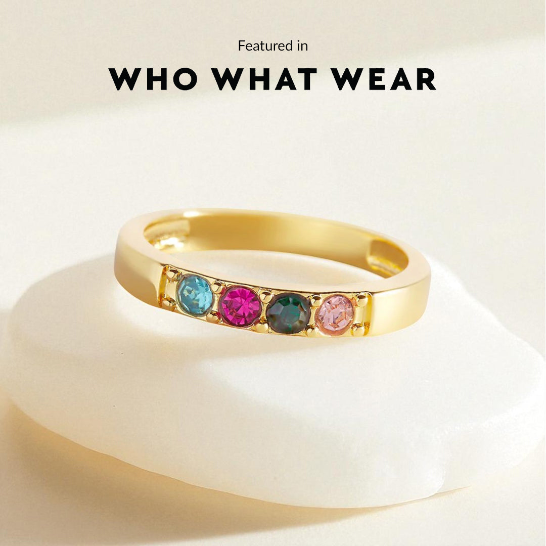 Gold ring with colorful gemstones on a beige background, featuring 'WHO WHAT WEAR'.