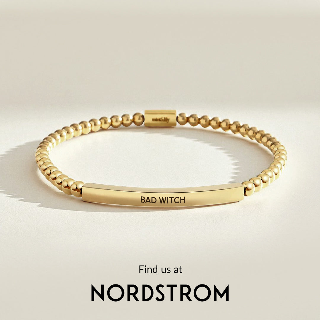 Gold bracelet with 'BAD WITCH' engraving on a light beige background, Nordstrom branding visible.