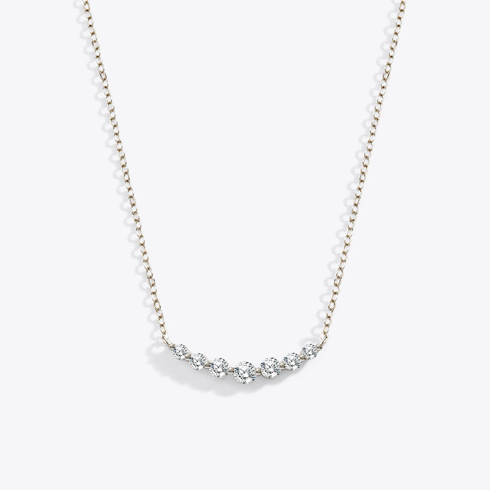 Delicate silver necklace with small diamonds on a white background