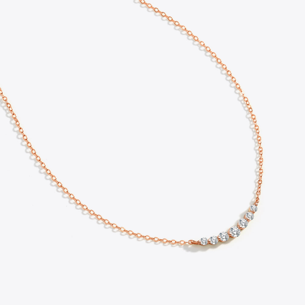 Rose gold necklace with small diamonds on a white background