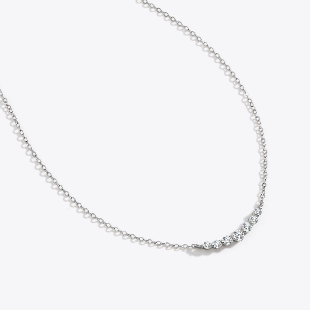 Silver necklace with small round beads on a white background