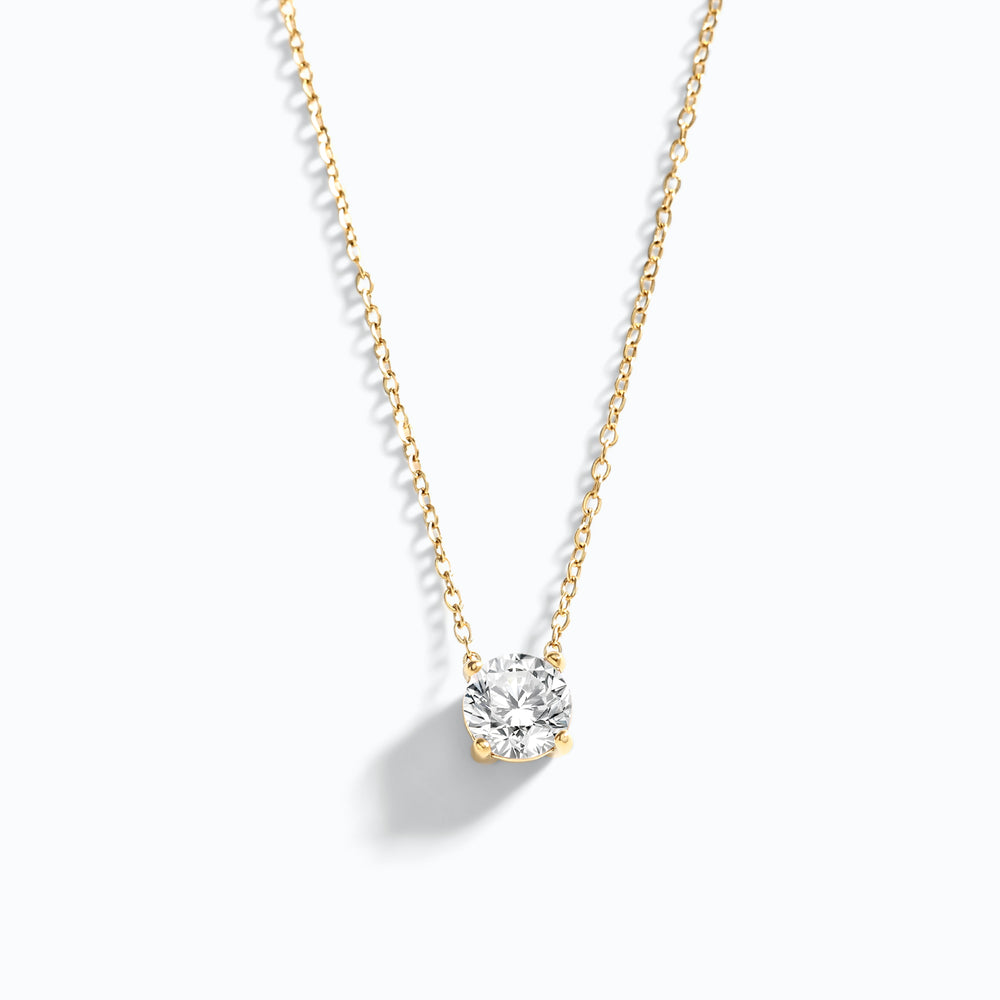 Gold necklace with a diamond pendant on a white background
