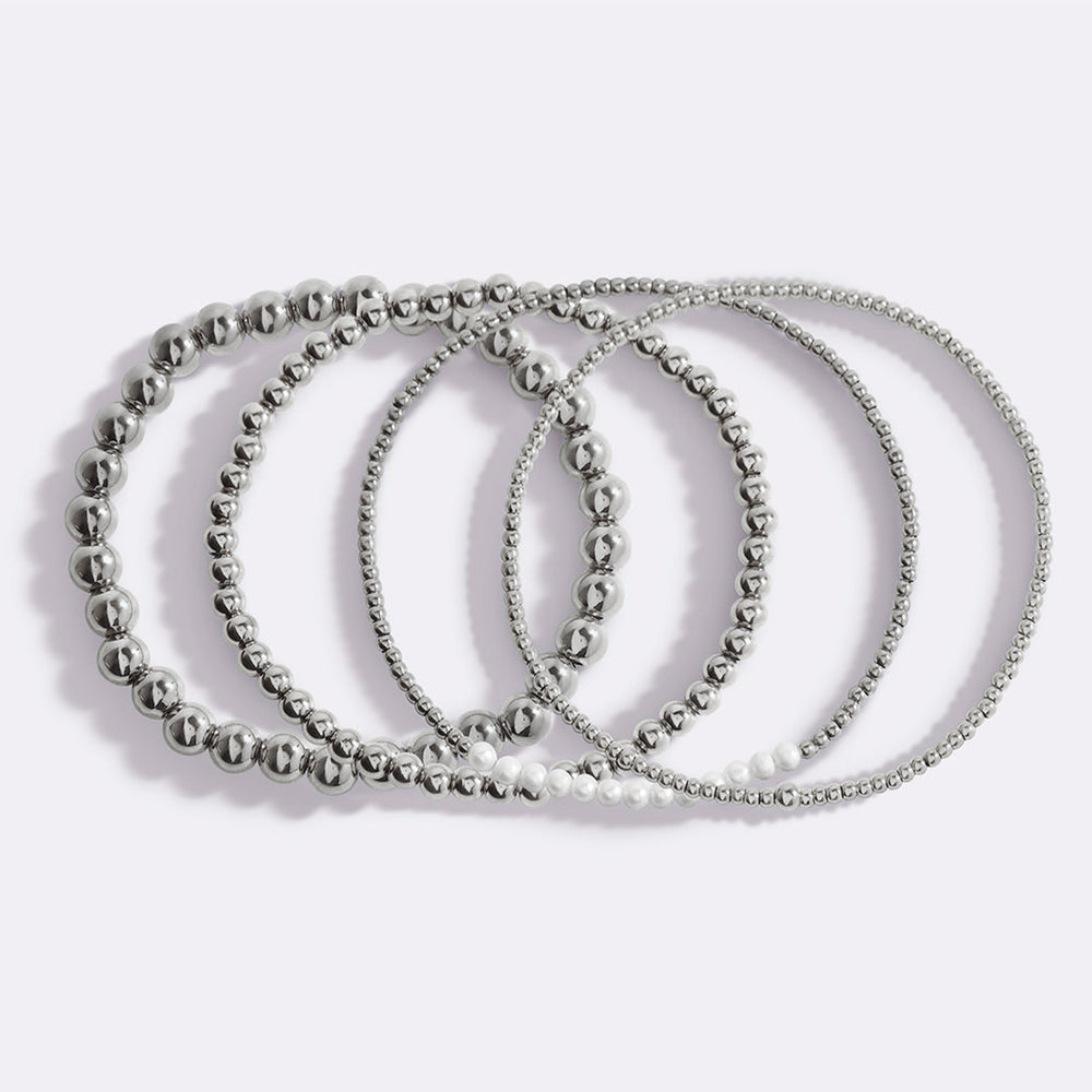 Set of three silver beaded bracelets on a white background